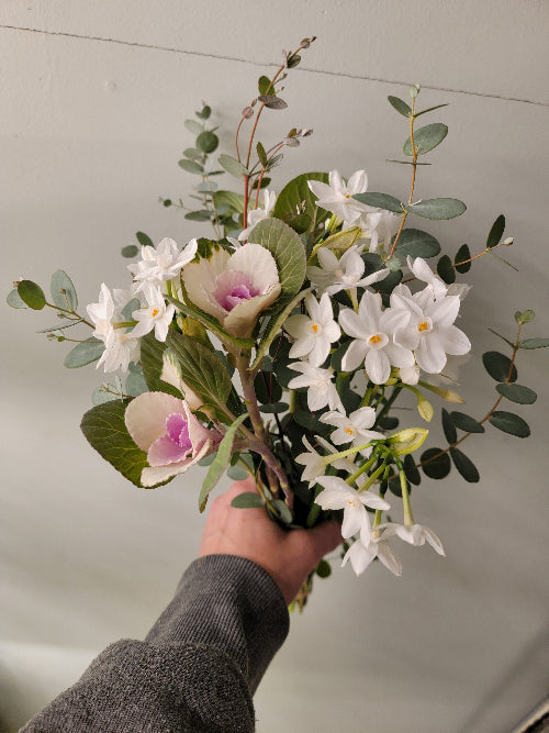 Bouquet of flowers held by a person against a neutral background