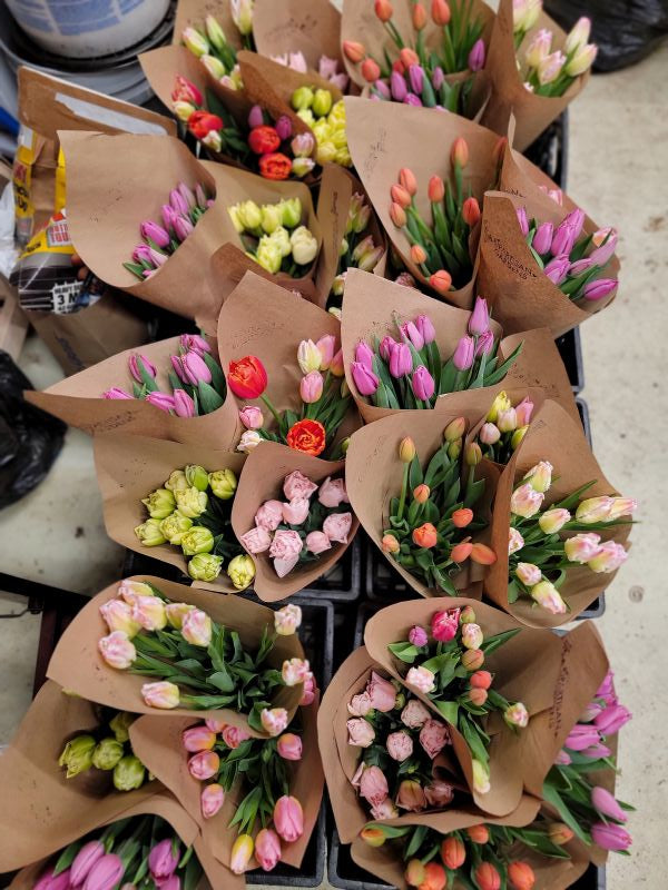 Bouquets of flowers in brown paper wraps on a table.